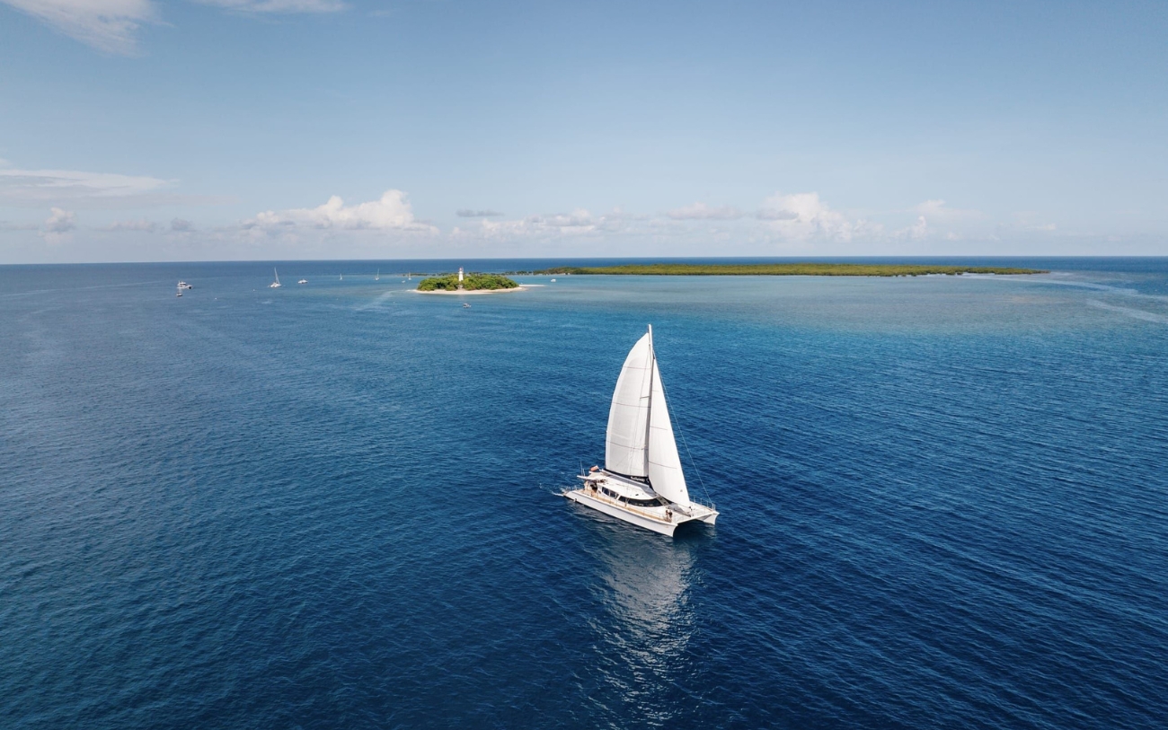 Sailaway catamaran cruising across the turquoise waters of the Great Barrier Reef during a Low Isles full-day tour near Port Douglas.