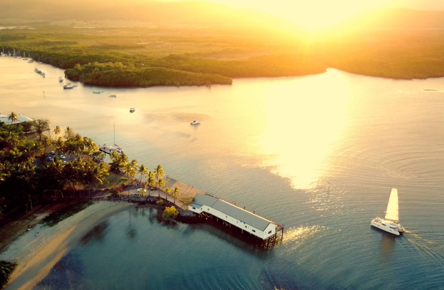 indigo charters sailing past sugar wharf in port douglas at sunset