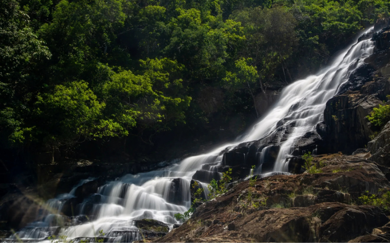Big Mowbray Falls cascading over a rocky mountainside surrounded by lush rainforest near Port Douglas.